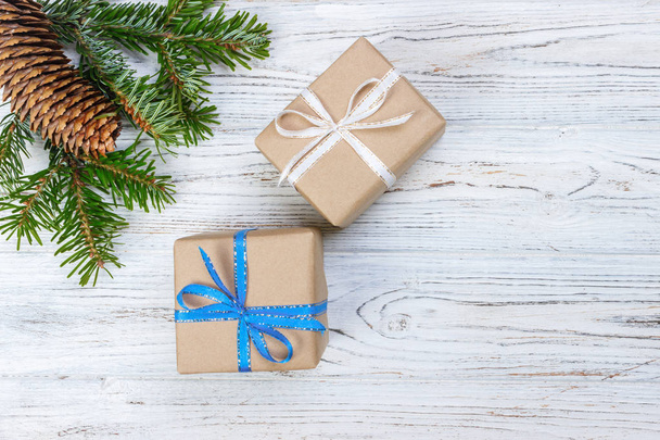 Caja de regalo de Navidad en el fondo de mesa de madera blanca, rama de abeto, conos de pino, marco, vista superior, espacio para el texto
 - Foto, imagen