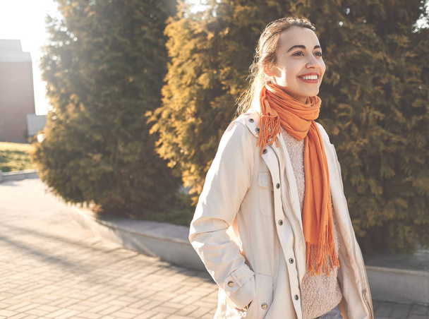 a beautiful young woman in a beige cloak on walk in autumn - Fotó, kép