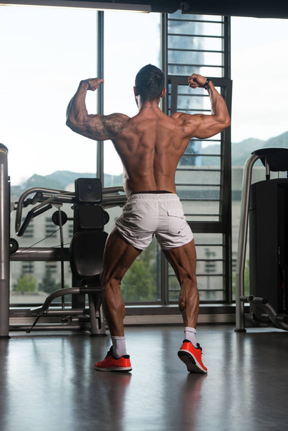 Bodybuilder Fitness Model Posing Double Biceps After Exercises - 写真・画像
