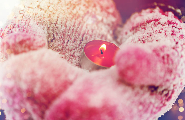 close up of hands in winter mittens holding candle - Фото, зображення