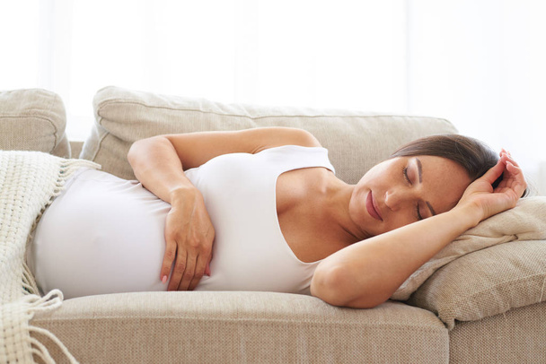 Στον ύπνο έγκυο γυναίκα στον καναπέ - Φωτογραφία, εικόνα
