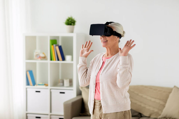 old woman in virtual reality headset or 3d glasses - Valokuva, kuva