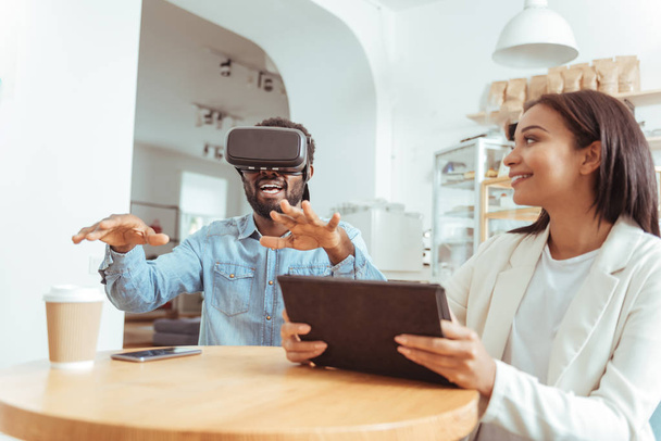 Smiling woman watching her friend test VR headset - Foto, Imagem