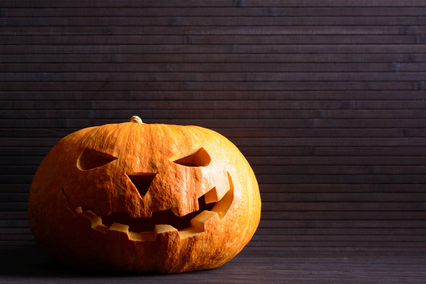 Calabaza de Halloween con cara de miedo en el fondo de listones de madera
 - Foto, imagen