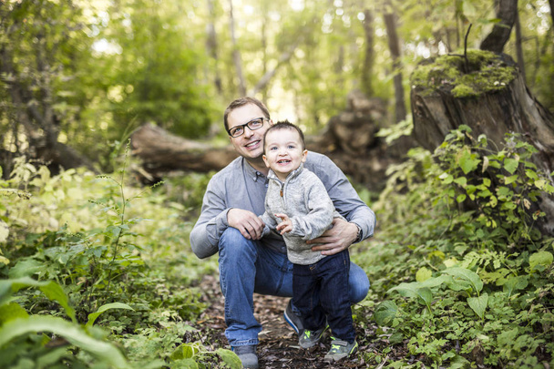 Little boy and his father on grass in autumn forest - Photo, image