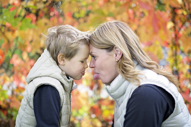 Mother with the child in autumn season - Foto, imagen