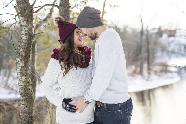 Pregnant couple have fun in winter nature - Foto, Imagen