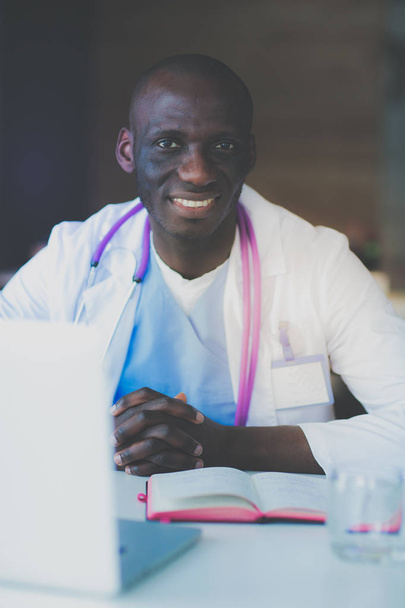 Young african doctor working on laptop at desk. Doctor. Workplace - Foto, Bild