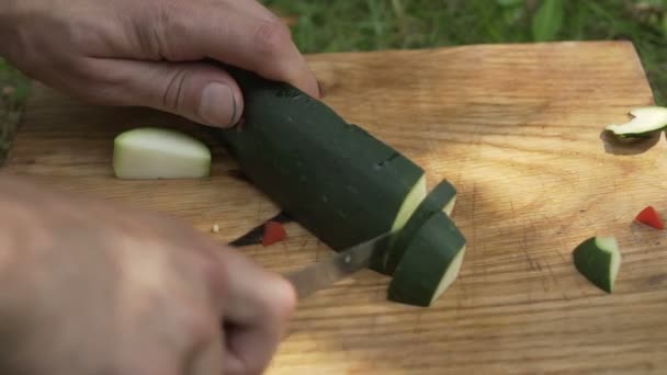man preparing zucchini in the open air - Video, Çekim