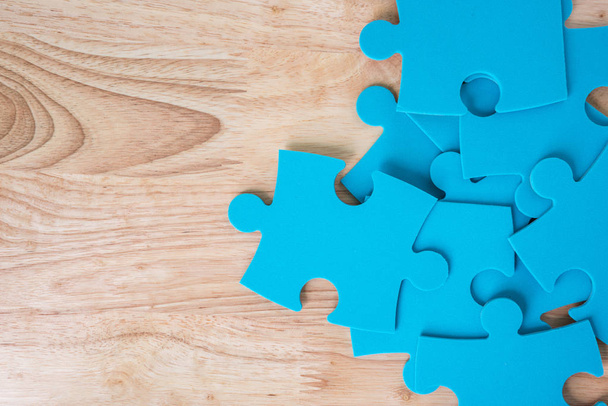 blue jigsaw puzzle pieces on wooden background - Photo, Image