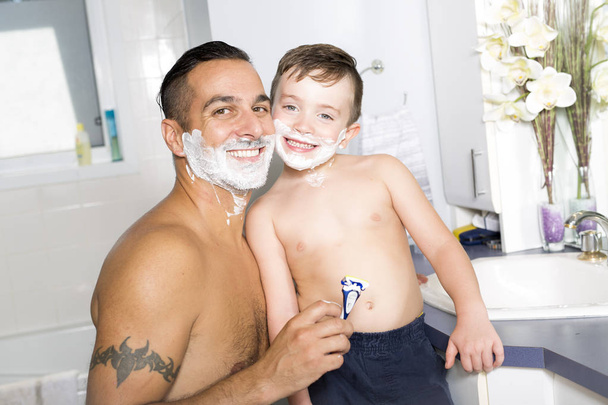 child have fun with dad shaving foam in the bathroom - Photo, Image