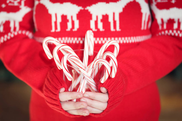 Κορίτσι εκμετάλλευση στοίβα καλάμια καραμέλα μέντα. Διακοπές Χριστουγέννων  - Φωτογραφία, εικόνα