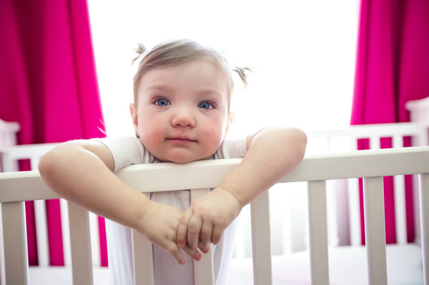 Cute little girl in cradle at baby room - Foto, Imagen