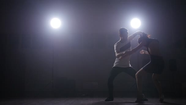 Ζευγάρι που χορεύει σε ένα σκοτεινό δωμάτιο με τον οπίσθιο φωτισμό - Πλάνα, βίντεο