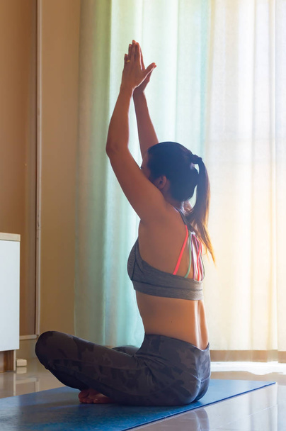 Asyalı kadın pratik yoga ve izlemek video bilinçlendirilmesini televi üzerinde - Fotoğraf, Görsel