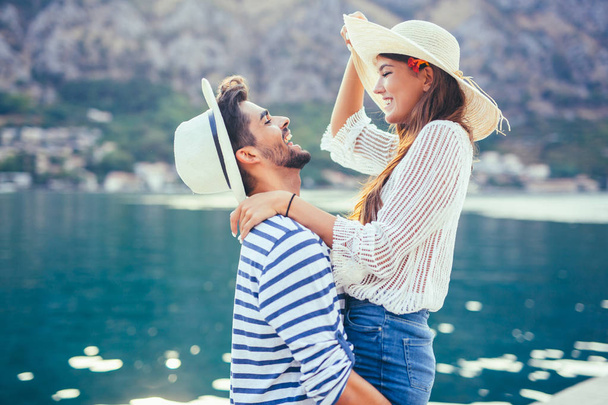 glückliches junges Paar beim Spaziergang am Hafen eines touristischen Badeortes - Foto, Bild