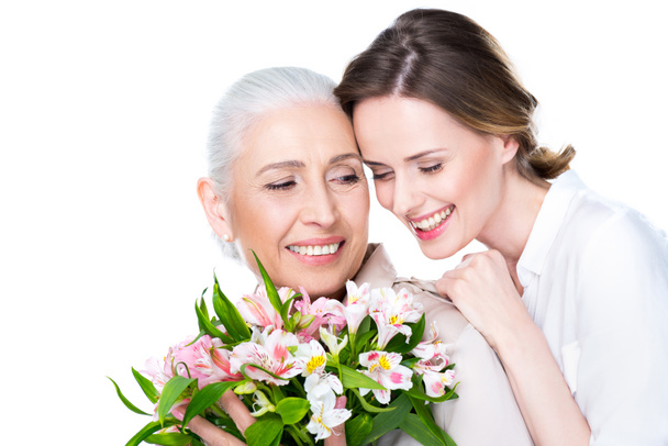 adult daughter and mother with bouquet   - Valokuva, kuva