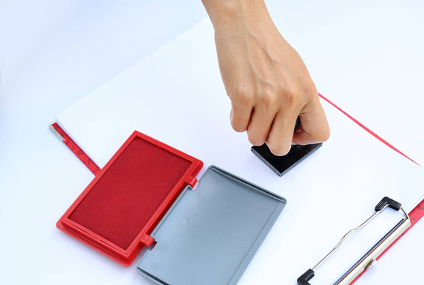 Hand holding rubber stamper with red Ink pad(box) on white paper. - Fotoğraf, Görsel