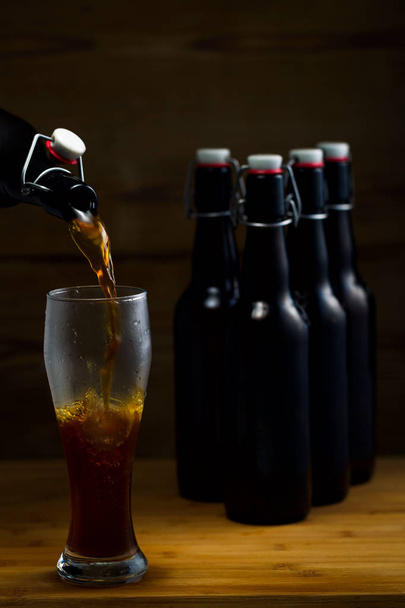 Beer glasses and beer bottles on a wooden background - Фото, изображение