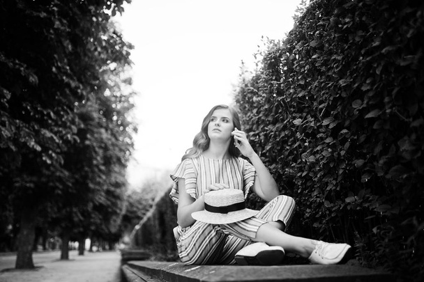 Portrait of an amazing young model in striped overall sitting in - Valokuva, kuva