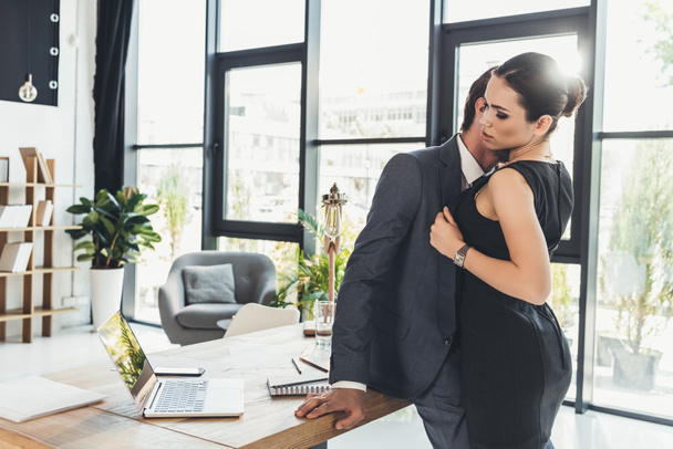 Мужчина целует женщину на шее в офисе
 - Фото, изображение