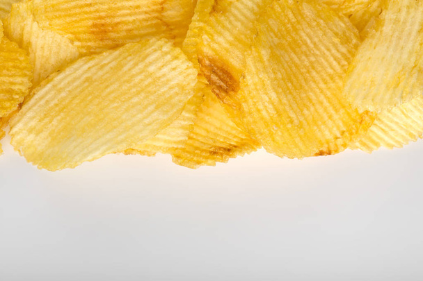 Хрустящие картофельные чипсы. Фаст-фуд. Картошка. Жирная вредная пища. гофрированные чипсы
 - Фото, изображение