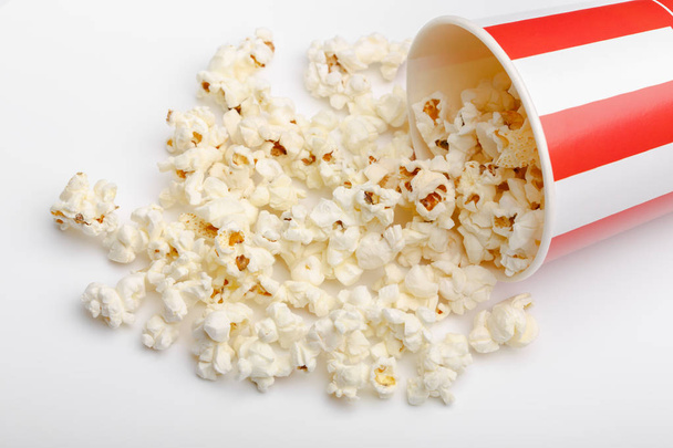 Popcorn in red and white cardboard box. Popcorn border isolated on white. Film. Fast food. Corn - 写真・画像