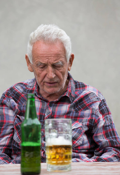 Hombre mayor con botella de cerveza y taza
 - Foto, Imagen