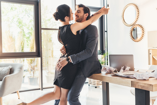 Young couple embracing in office - Foto, Imagen