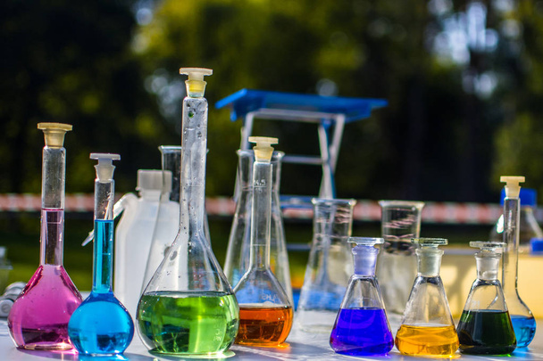 laboratoriumapparatuur - chemische glaswerk gevuld met kleurrijke vloeistoffen - Foto, afbeelding