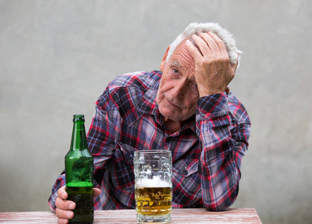 Starší muž s pivní láhve a hrnek - Fotografie, Obrázek