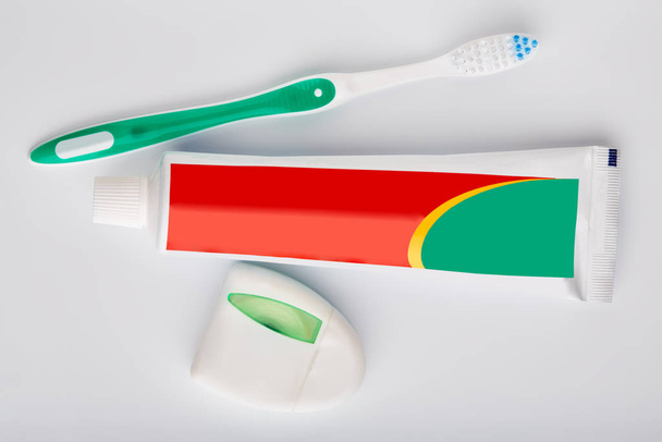 Zahnbürste und Zahnpasta isoliert auf weiß. Zahnseide. Gesundheit und Zahnhygiene. Körperpflege. einen gesunden Mund. Toilettenartikel. Zubehör. - Foto, Bild