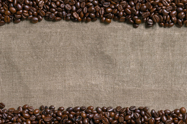 Granos de café sobre fondo de arpillera. - Foto, imagen