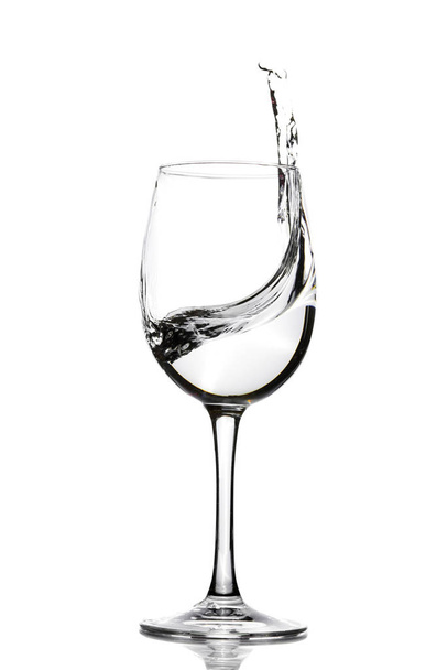 ワイン用のガラスの透明な水のスプラッシュ。水が跳ねます。水を飲む。アルコール. - 写真・画像