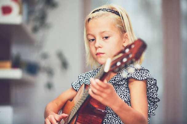 Girl learning to play to the guitar  - Zdjęcie, obraz