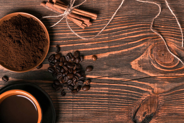 Kopje koffie, koffiebonen, gemalen koffie op houten tafel pagina - Foto, afbeelding