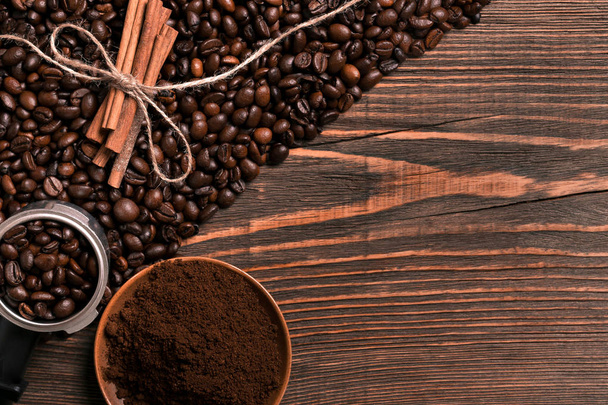 Granos de café, palitos de canela y café molido en madera rústica
 - Foto, Imagen