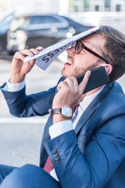 stressed businessman with newspaper and smartphone - Zdjęcie, obraz