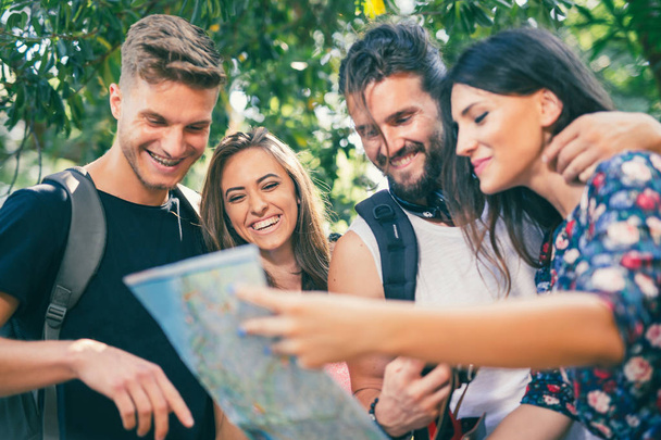 Los turistas jóvenes en busca de dirección utilizando el mapa de papel
 - Foto, imagen