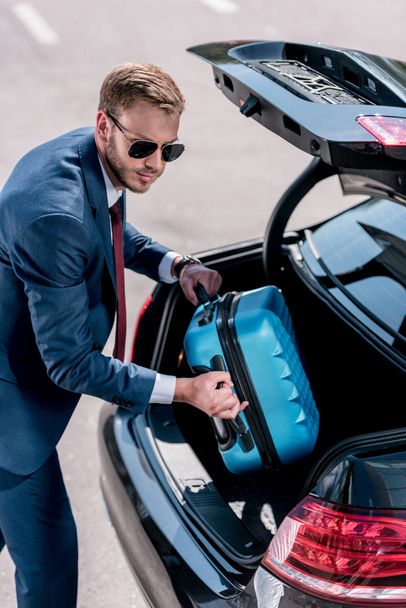 businessman with suitcase at car - Foto, afbeelding