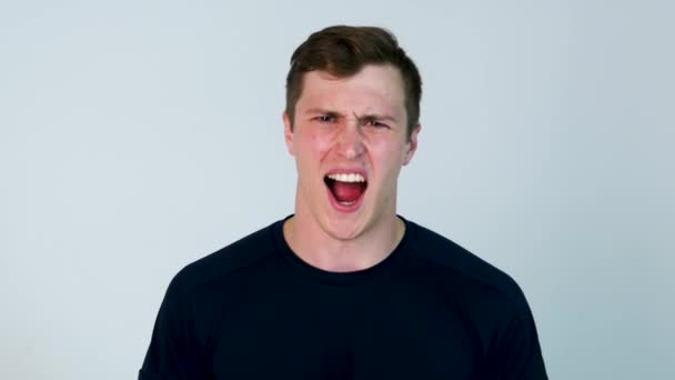Portrait of young angry man screaming isolated on white background. Close up portrait of young man screaming. Very angry casual man screaming - Footage, Video