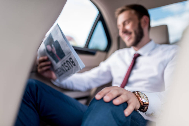 man with newspaper on backseat of car - Zdjęcie, obraz