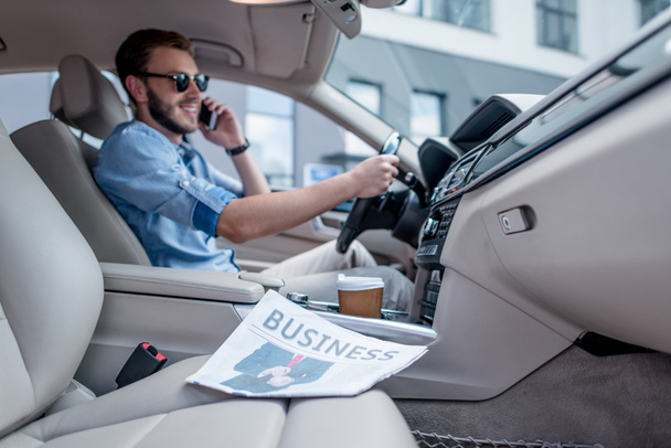 man with smartphone driving car - Foto, afbeelding