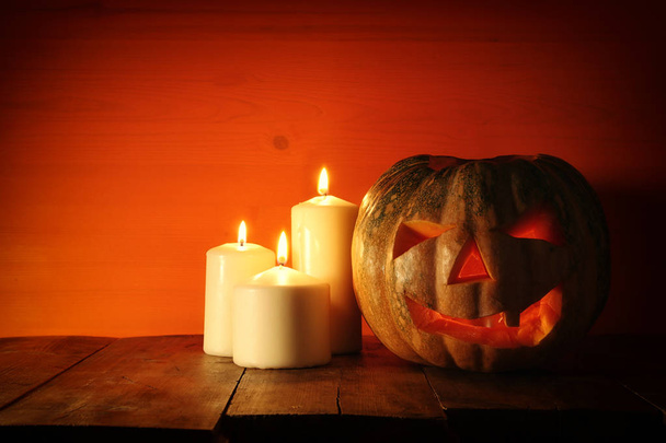 Halloween Pumpkin on wooden table in front of spooky dark background. Jack o lantern - Foto, Imagem