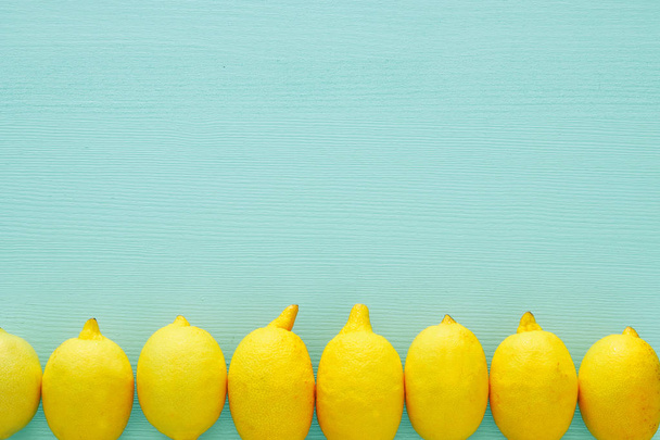 Top view of fresh lemons over blue wooden background - Foto, Bild