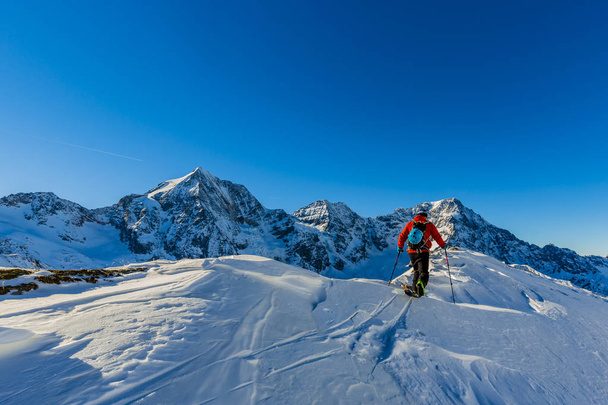 Vuorikiipeilijä backcountry ski kävely pitkin luminen harjanteella kanssa
  - Valokuva, kuva