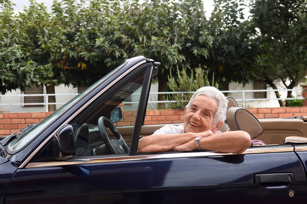 portrait of a senior woman with convertible car - Foto, imagen