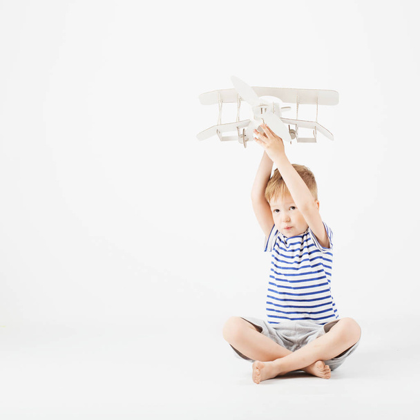 Αγόρι παιδί παίζοντας με toy αεροπλάνο χαρτί και ονειρεύεται becomi - Φωτογραφία, εικόνα