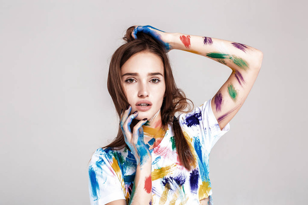 young woman smeared in multicolored paint. - Foto, Imagen