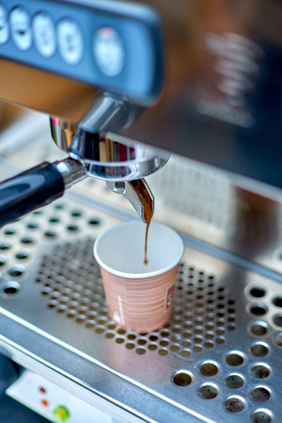 coffee machine preparing fresh coffee and pouring into paper cup - 写真・画像